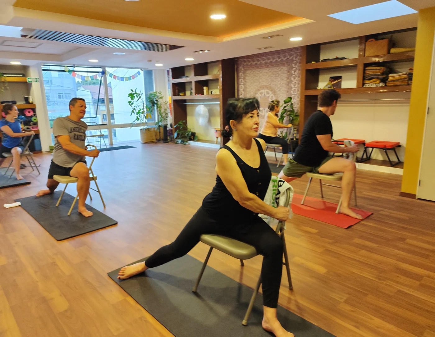 Clase grupal de yoga en silla en Prana Yoga Room
